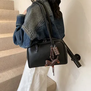 Retro black leather bowling handbag for women styled with a denim jacket on a staircase