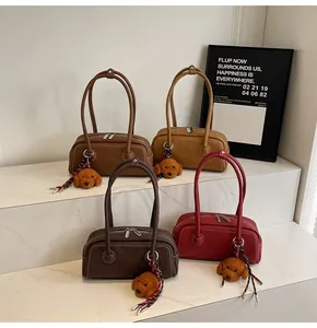 Detail of retro cylinder shoulder bags in four colors with stitching and plush charms