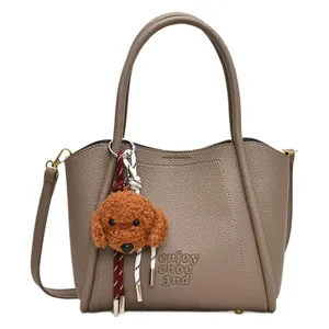 Retro taupe leather bucket bag with top handles and cute teddy bear plush charm
