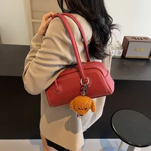 Retro red faux leather underarm shoulder bag with contrast stitching and plush charm