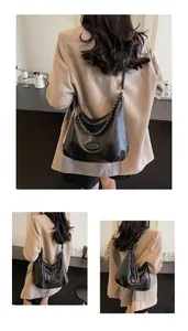 Dettaglio borsa hobo in pelle martellata nera con catena argentata e tracolla in pelle