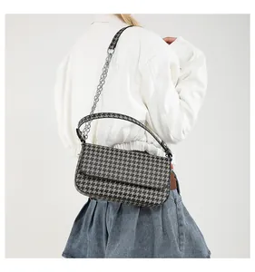 Modellansicht der großen Hahnentritt-Schultertasche mit Kettenriemen und Klappendesign