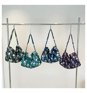 Detail of four gothic hobo bags featuring skull and rose prints on nylon fabric