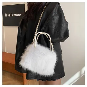 White faux fur handbag with pearl gold chain strap shown on a model in a minimal setting