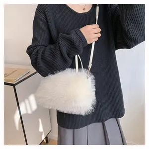 Detail of soft white faux fur shoulder bag with slender strap and gold metal clasp
