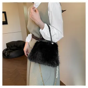Detail of black faux fox fur handbag featuring pearl shoulder strap and metallic chain