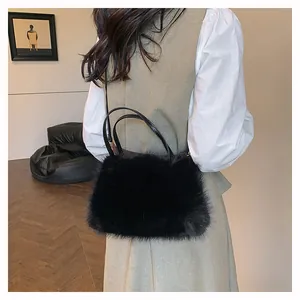Furry black plush handbag detail with soft texture and slim shoulder strap on model