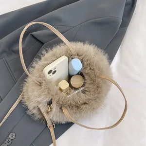 Furry apricot round handbag with plush texture on dark suit backdrop and shoulder strap