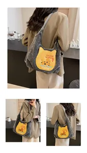 Détail du sac hobo en velours côtelé gris avec poche chat jaune et broderie