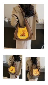 Détail du sac à bandoulière en velours côtelé marron avec broderie de chien