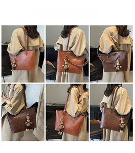 Vues détaillées d'un sac cabas marron rétro avec texture souple et breloque lapin mignonne
