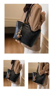 Détail d'un grand sac cabas noir en similicuir avec lettrage doré et charm lapin mignon