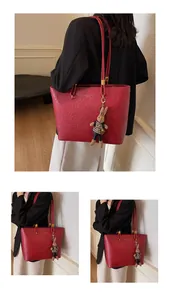 Détail d'un grand sac cabas rouge vintage avec lettrage doré et pendentif lapin