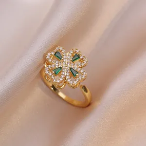 Détail d'une bague trèfle dorée sertie de gemmes vertes et de zircons blancs