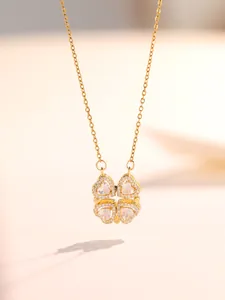 Primer plano del collar de trébol dorado con pétalos de circonita en forma de corazón