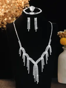 Detailed view of silver crystal fringe necklace and bridal jewelry set on black display