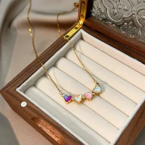 Elegante collar de trébol dorado con pétalos de corazón irisados en caja de madera