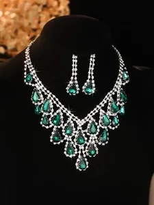 Detail of bridal jewelry set with V-shaped green water-drop gems and white diamonds