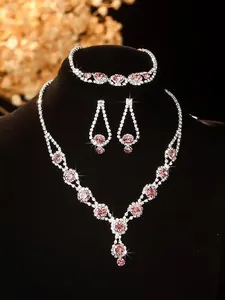 Detailed macro view of bridal jewelry set with silver chain and pink crystal teardrops