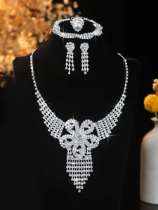 Macro view of bridal jewelry set featuring sparkling floral necklace and diamond earrings