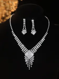 Detailed view of bridal jewelry set featuring rhinestone fringe necklace on black bust