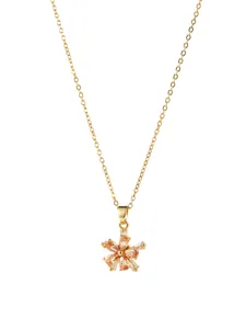 Macro detail of rotating zircon flower pendant with champagne stones on gold chain