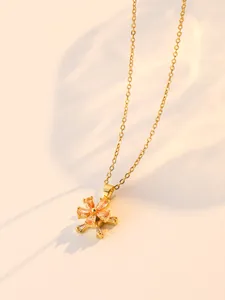 Close-up of golden spinning flower necklace with sparkling zircon petals and central bead