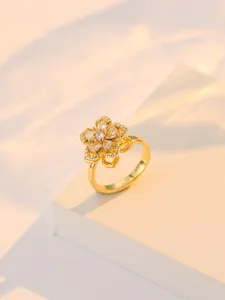 Vue détaillée du pendentif fleur rotative dorée avec cristaux de zircon étincelants