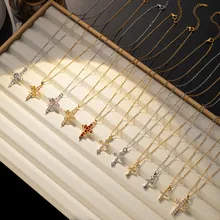 Detalle de collares de cruz en oro y plata con cristales en una bandeja de joyería fina