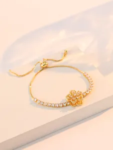 Détail du bracelet fleur en zircon doré avec fermoir coulissant ajustable sur fond blanc
