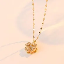 Primer plano detallado de un collar dorado con colgante de trébol y piedras brillantes