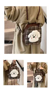 Detailed view of plaid tote bag featuring a plush puppy patch and brown leather trim