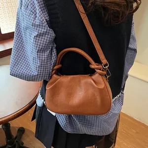 Caramel brown ruched leather shoulder bag with stylish knot handle and retro design