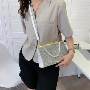 Elegante zilveren crossbodytas met lovertjes en parelhandvat en witte lederen riem