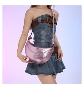 Detail van roze metallic halve maan tas met laser spiegelende afwerking en geweven riem
