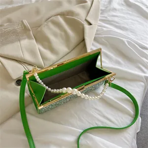 Chique groene tweed handtas met parel handvat en gouden metalen frame afwerking