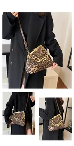 Dettaglio borsa a conchiglia leopardata con catena dorata e chiusura vintage in metallo