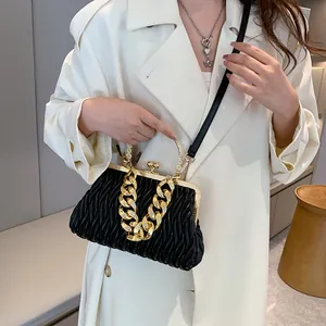 Fashionable black pleated crossbody bag with gold metal frame and chain on model