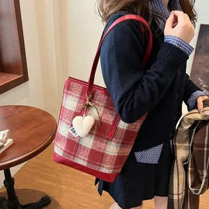Chic red and grey plaid wool tote bag with heart charm shown on model in warm studio