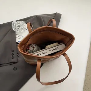 Brown contrast stitch tote bag showing spacious interior with books and umbrella