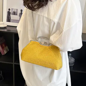 Funkelnde gelbe Strass-Clutch mit Silberkette, getragen von einem Model in legerem Ambiente