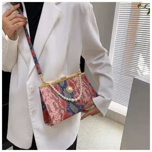 Détail du sac à main texturé serpent coloré avec chaîne de perles et fermoir en métal doré