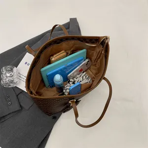 Bolso tote grande marrón con monograma mostrando interior espacioso para tablet y más