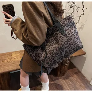 Gros plan d'un sac cabas à imprimé léopard porté à l'épaule par un mannequin