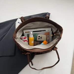 Grand sac cabas léopard contenant une tablette, des livres et objets essentiels