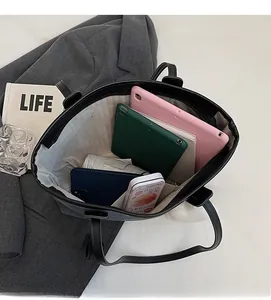 Spacious black tote bag interior showing capacity for tablets and folding umbrella