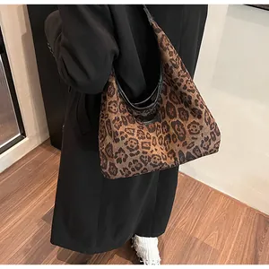 Detail of hobo bag with leopard print fabric and black leather trim for women