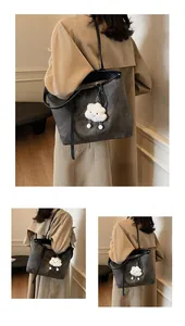 Detail of dark grey tote bag featuring washed texture and cute plush cloud charm