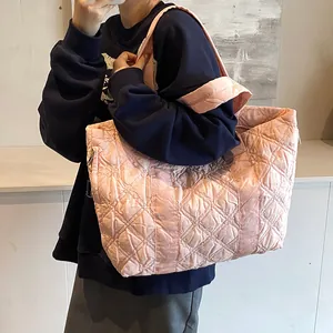 Grande borsa tote imbottita rosa con motivo a rombi indossata da una modella per il tempo libero