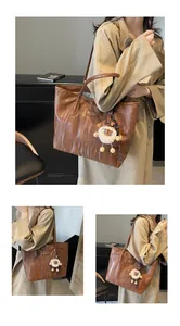 Close-up of brown ripple texture tote bag with sheep pendant and fashion logo details